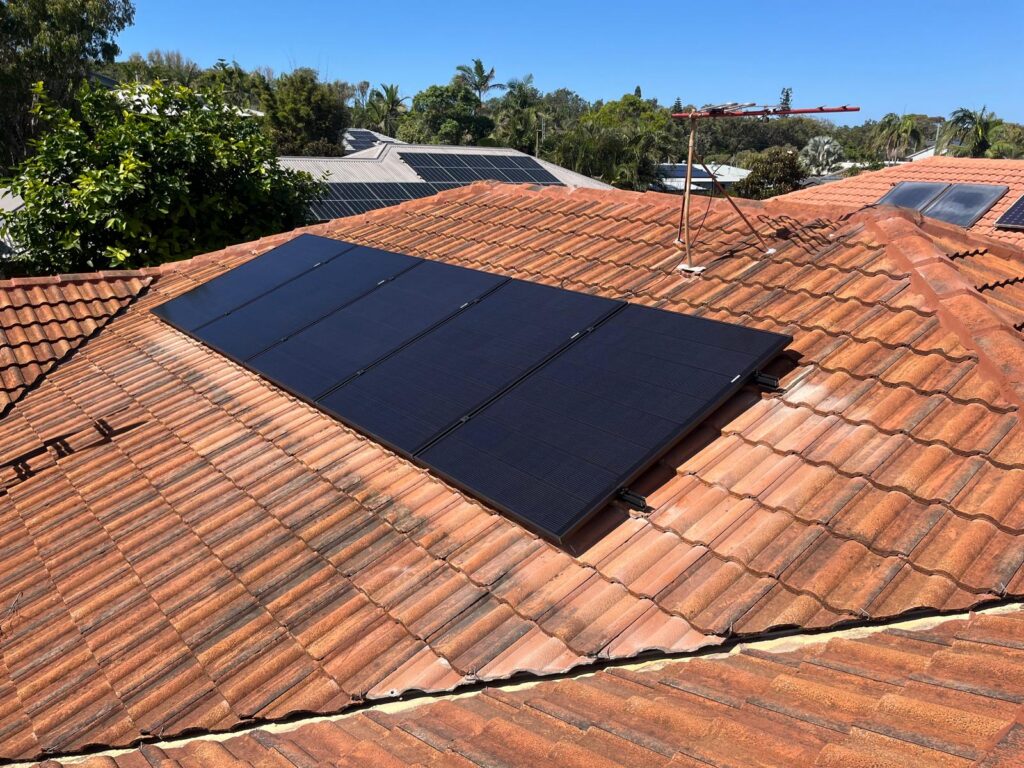 Black solar panels installed on a tiled roof on the Gold Coast