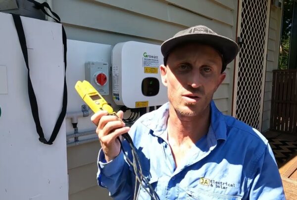 Jeremy from JA Electrical & Solar using a clamp meter to test a solar inverter during fault finding