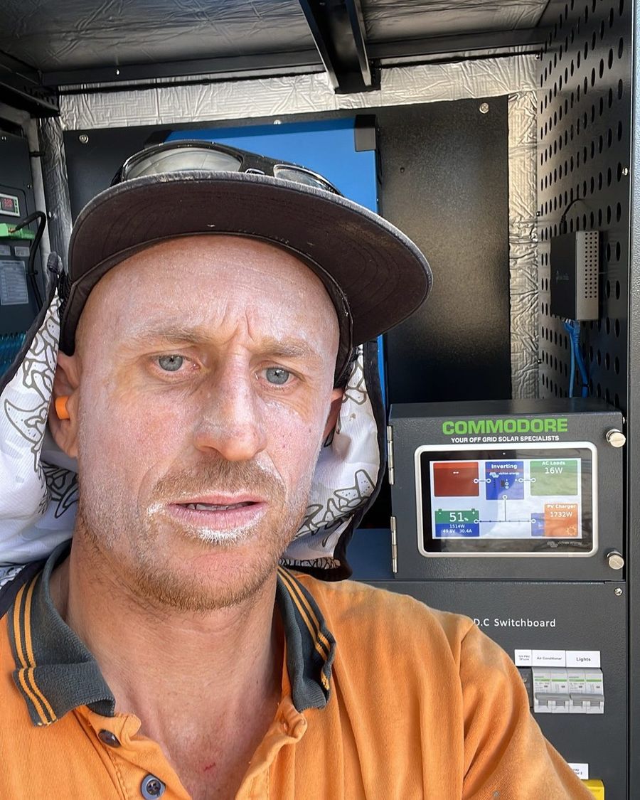 Jeremy, owner and electrician at JA Electrical & Solar, beside an off-grid solar system